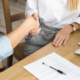Two women partners handshaking after signing business contract at meeting, female client or customer and manager agent broker closing good deal, female hands shaking making agreement, close up view